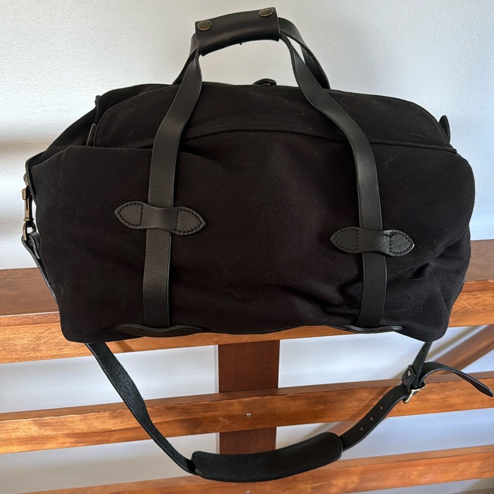 Filson rugged twill duffle. Small, black with black leather strap.